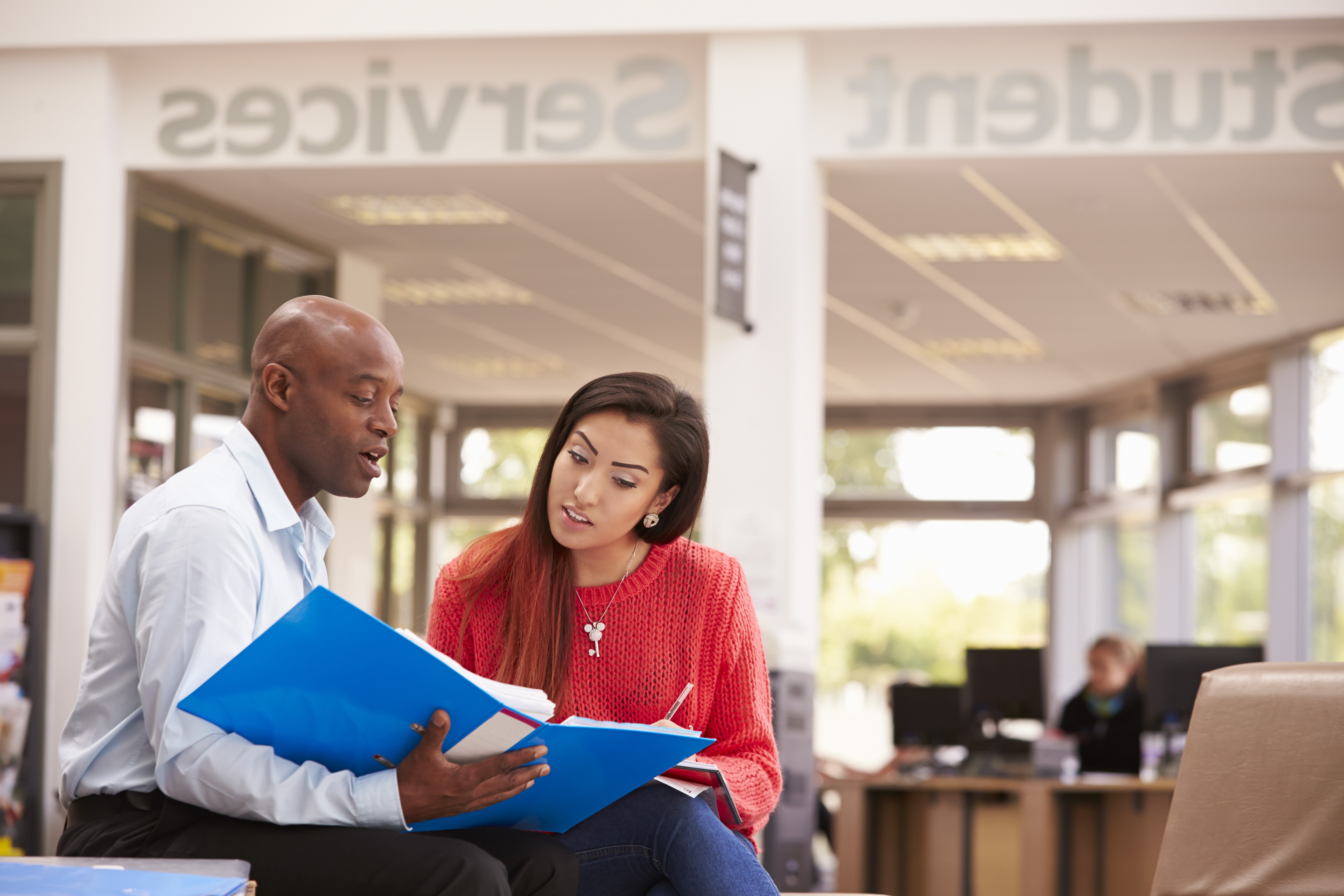 College Student Having Meeting With Tutor To Discuss Work