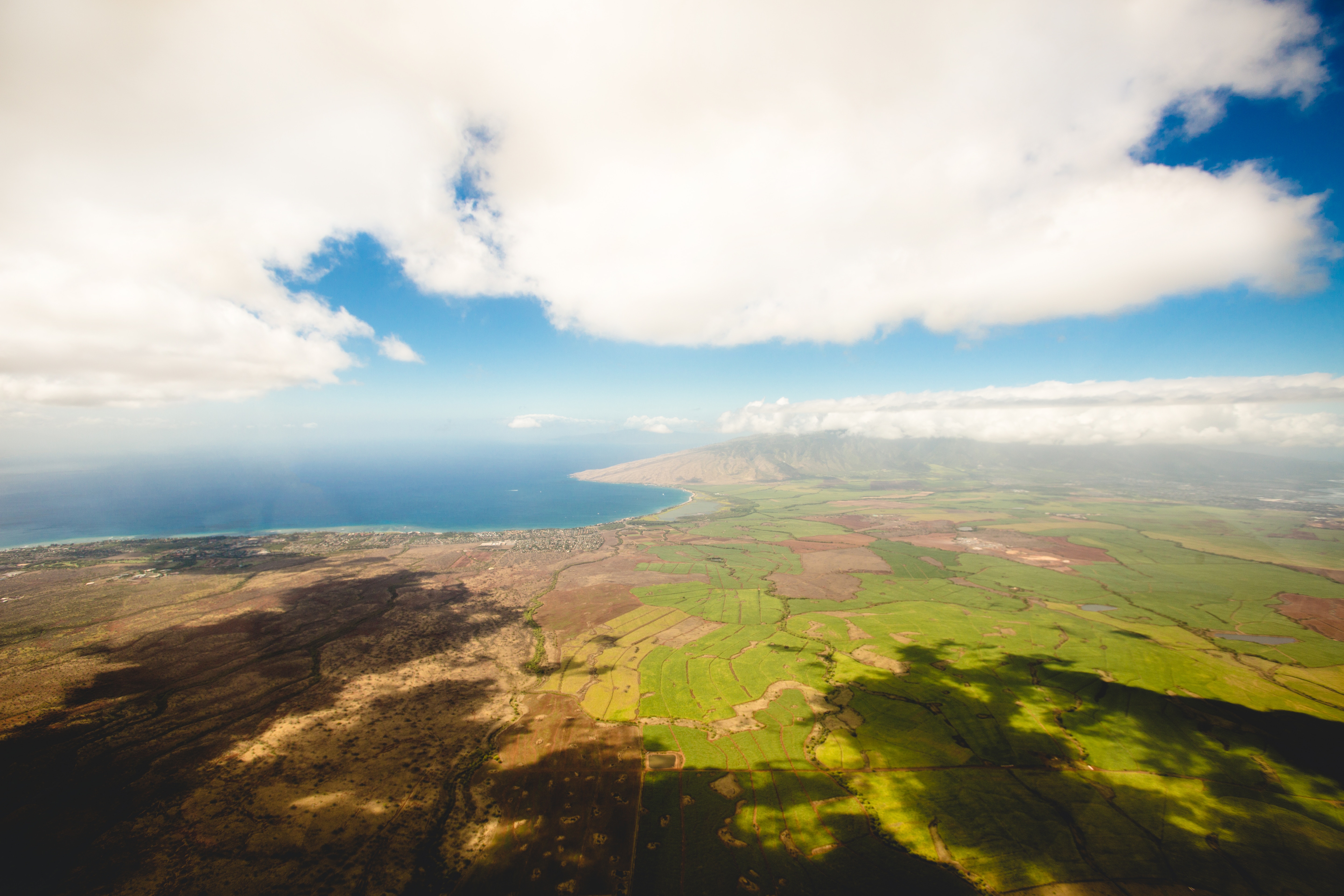 airplane overview of the green pasture and blue skys