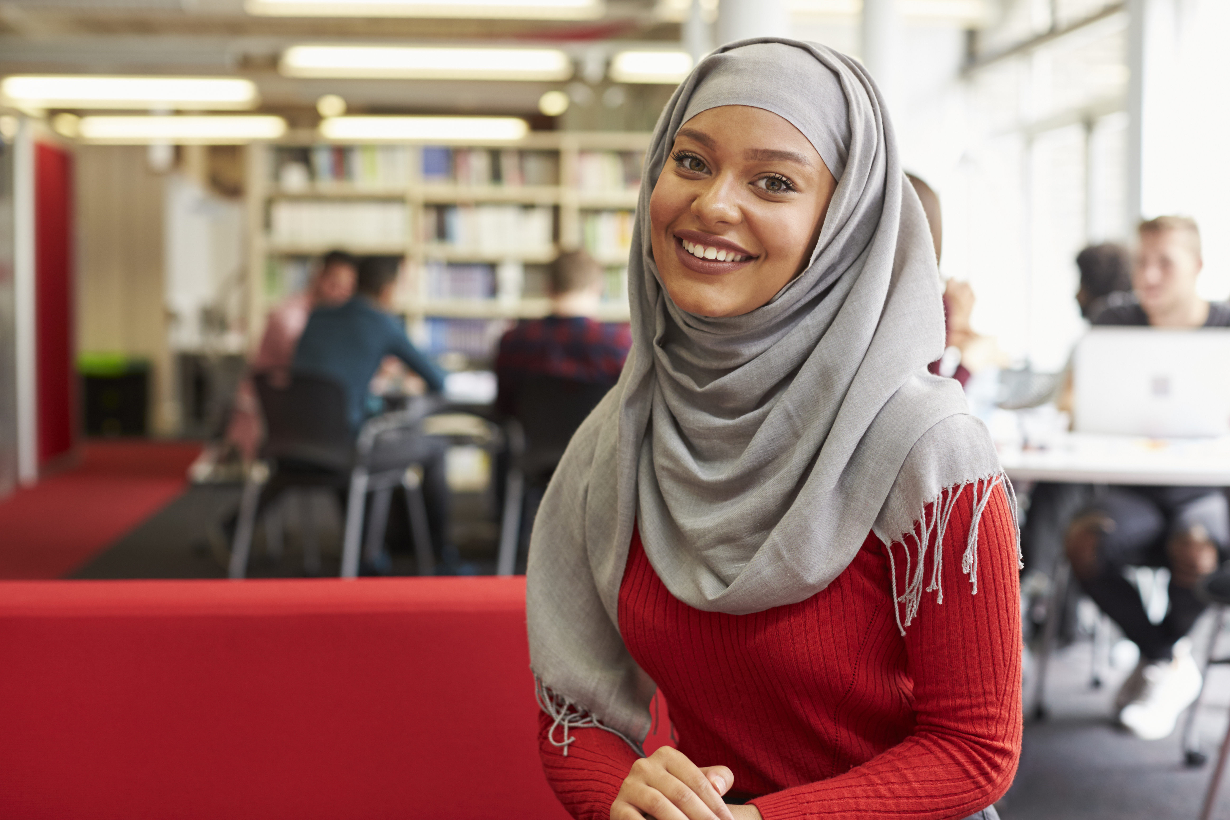 portrait with hijab at her university working in the library